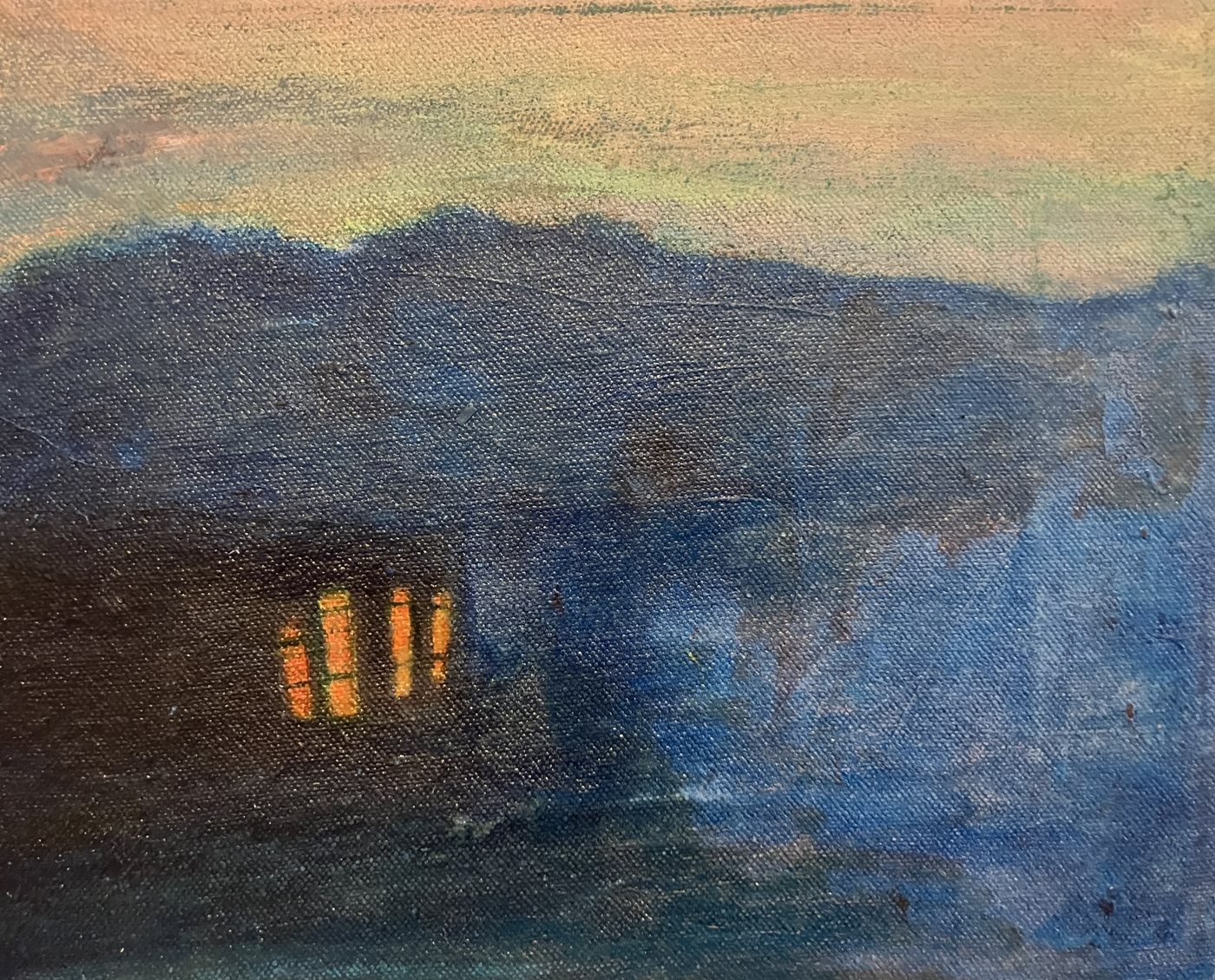 Deep blue hills under a peach sky, with four lit orange windows in a dark building