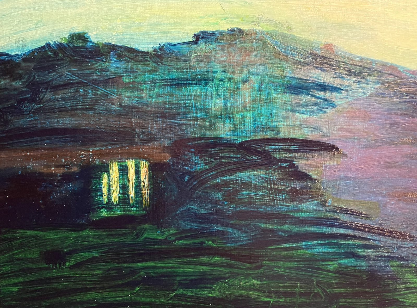 Night landscape: dark blue-green hills under a pale sky, with a cluster of glowing yellow windows
